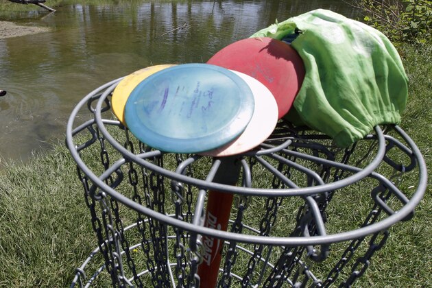 Jake Weiss, left, and his friend Jordan Warunek, right, search for lost golf discs in a river along a disc golf course during the warm spring weather in Lancaster, N.Y., Friday, May 18, 2012. (AP Photo/David Duprey)