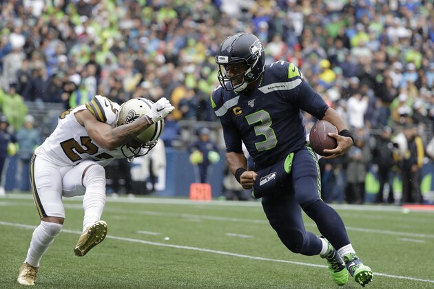 Seattle Seahawks quarterback Russell Wilson, right, scores a touchdown on a run as New Orleans Saints' Marshon Lattimore tries to stop him during the second half of an NFL football game, Sunday, Sept. 22, 2019, in Seattle. (AP Photo/Ted S. Warren)