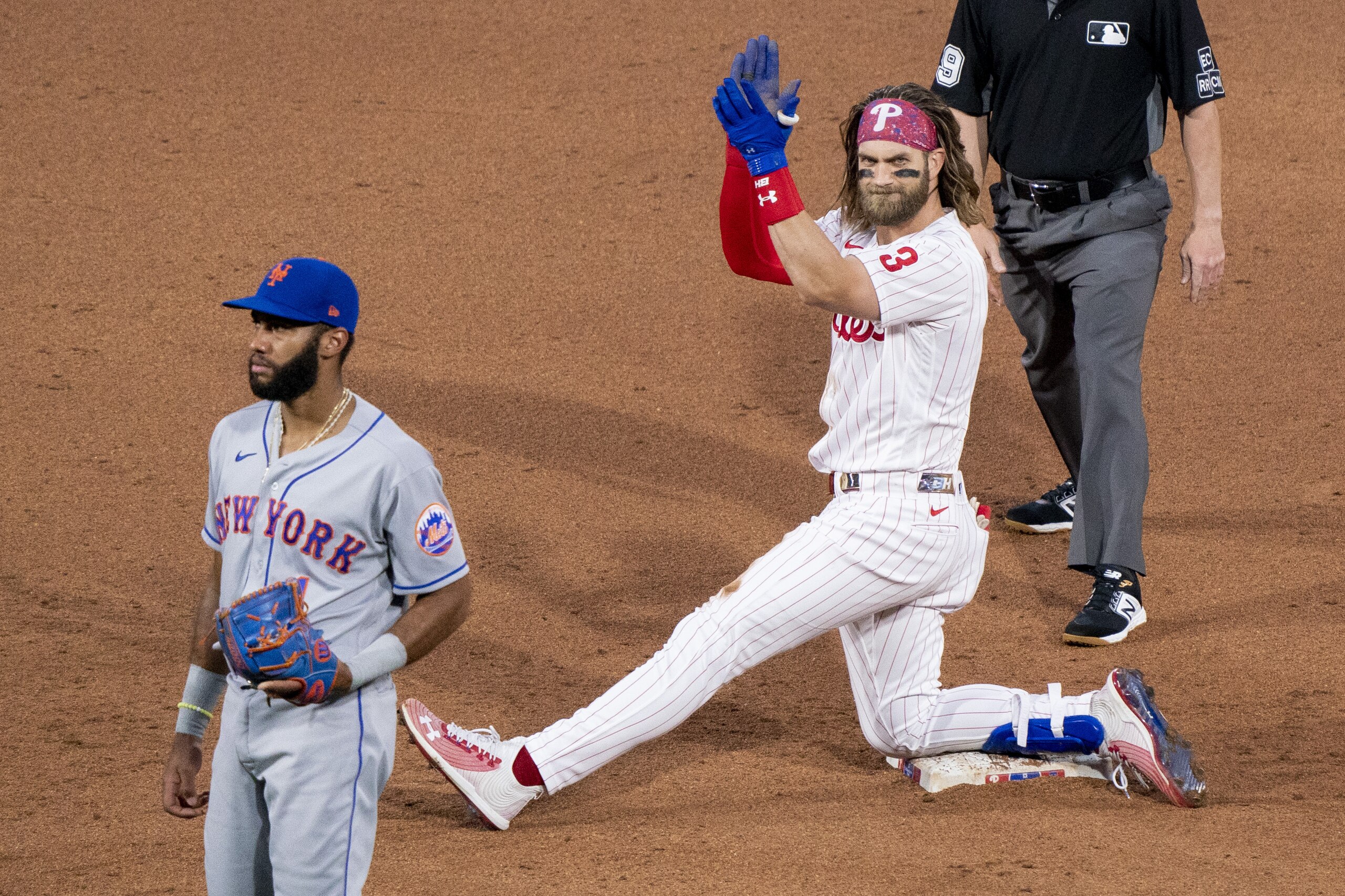 Philadelphia Phillies' Bryce Harper, center, reacts to his RBI double with New York Mets' Amed Rosario, left, looking on during a baseball game, Saturday, Aug. 15, 2020, in Philadelphia. The Phillies won 6-2. (AP Photo/Chris Szagola) Philadelphia Phillies' Bryce Harper, center, reacts to his RBI double with New York Mets' Amed Rosario, left, looking on during a baseball game, Saturday, Aug. 15, 2020, in Philadelphia. The Phillies won 6-2. (AP Photo/Chris Szagola)