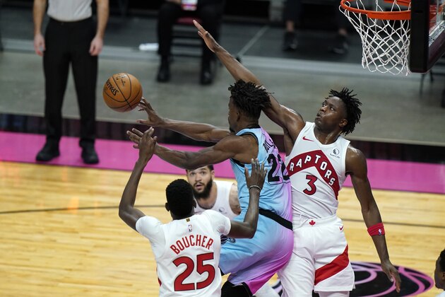Toronto Raptors forward Chris Boucher (25) and forward OG Anunoby (3) defend Miami Heat forward Jimmy Butler (22) during the second half of an NBA basketball game, Wednesday, Feb. 24, 2021, in Miami. The Heat won 116-108. (AP Photo/Lynne Sladky)