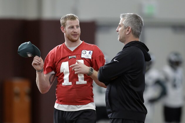 Injures Philadelphia Eagles quarterback Carson Wentz (11) talks with offensive coordinator Frank Reich, right, during a practice for the NFL Super Bowl 52 football game Thursday, Feb. 1, 2018, in Minneapolis. Philadelphia is scheduled to face the New England Patriots Sunday. (AP Photo/Eric Gay)