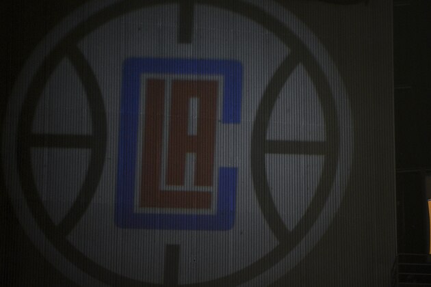 The retired jerseys of late Los Angeles Lakers' Kobe Bryant hangs above the arena next to a projected logo of the Los Angeles Clippers prior to an NBA basketball game against the Sacramento Kings in Los Angeles, Thursday, Jan. 30, 2020. (AP Photo/Kelvin Kuo)