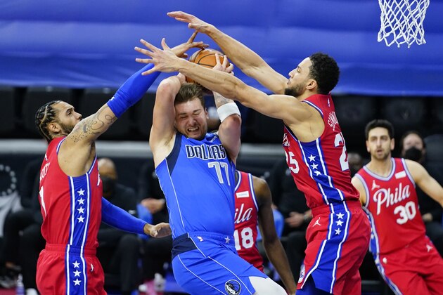 Dallas Mavericks' Luka Doncic, center, cannot get a shot past Philadelphia 76ers' Mike Scott, left, and Ben Simmons during the first half of an NBA basketball game, Thursday, Feb. 25, 2021, in Philadelphia. (AP Photo/Matt Slocum)