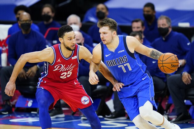 Dallas Mavericks' Luka Doncic (77) tries to dribble past Philadelphia 76ers' Ben Simmons (25) during the second half of an NBA basketball game, Thursday, Feb. 25, 2021, in Philadelphia. (AP Photo/Matt Slocum)