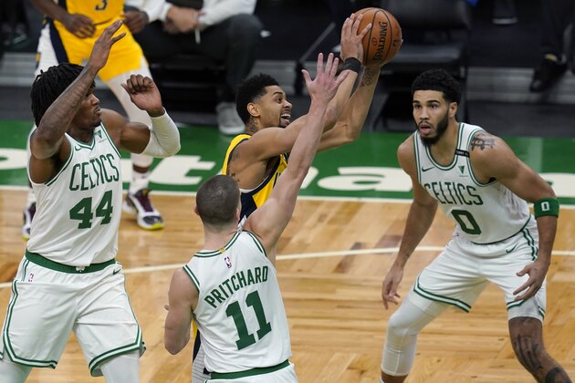 Indiana Pacers guard Jeremy Lamb (26) drives to the hoop against Boston Celtics center Robert Williams III (44), guard Payton Pritchard (11) and forward Jayson Tatum (0) in the first half of an NBA basketball game, Friday, Feb. 26, 2021, in Boston. (AP Photo/Elise Amendola)