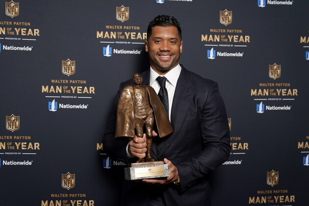 Seattle Seahawks quarterback Russell Wilson poses with his trophy after winning the Walter Payton NFL Man of the Year award during the NFL Honors ceremony as part of Super Bowl 55 Friday, Feb. 5, 2021, in Tampa, Fla. (AP Photo/Charlie Riedel)