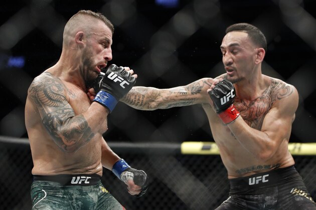 Max Holloway hits Alexander Volkanovski in a mixed martial arts featherweight championship bout at UFC 245, Saturday, Dec. 14, 2019, in Las Vegas. (AP Photo/John Locher)