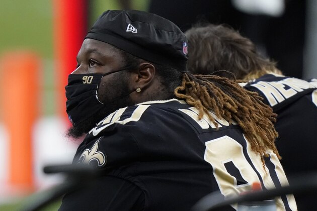 New Orleans Saints defensive tackle Malcom Brown (90) wears a face mask as he sits the bench during the first half of an NFL divisional round playoff football game against the Tampa Bay Buccaneers, Sunday, Jan. 17, 2021, in New Orleans. (AP Photo/Brynn Anderson)