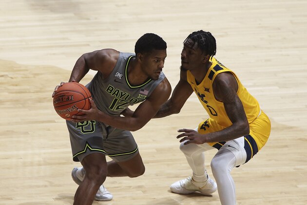 Baylor guard Jared Butler, left, is defended by West Virginia guard Kedrian Johnson, right, during the first half of an NCAA college basketball game Tuesday, March 2, 2021, in Morgantown, W.Va. (AP Photo/Kathleen Batten)