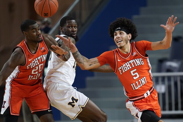 Illinois guard Andre Curbelo (5) chases a loose ball as Da'Monte Williams (20) defends Michigan guard Chaundee Brown (15)in the first half of an NCAA college basketball game in Ann Arbor, Mich., Tuesday, March 2, 2021. (AP Photo/Paul Sancya)