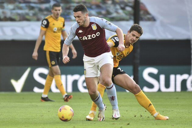 Aston Villa's John McGinn, left, and Wolverhampton Wanderers' Leander Dendoncker challenge for the ball during the English Premier League soccer match between Wolverhampton and Aston Villa at Molineux Stadium in Wolverhampton, England, Saturday, Dec. 12, 2020. (AP Photo/Rui Vieira, Pool)