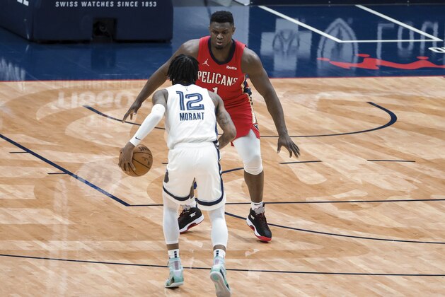 Memphis Grizzlies guard Ja Morant (12) drives in against New Orleans Pelicans forward Zion Williamson (1) in the second quarter of an NBA basketball game in New Orleans, Saturday, Feb. 6, 2021. (AP Photo/Derick Hingle)