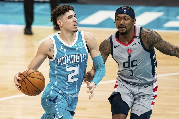 Charlotte Hornets guard LaMelo Ball (2) drives to the basket while guarded by Washington Wizards guard Bradley Beal (3) during the second half of an NBA basketball game in Charlotte, N.C., Sunday, Feb. 7, 2021. (AP Photo/Jacob Kupferman)