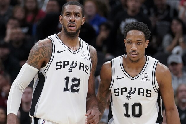 San Antonio Spurs' LaMarcus Aldridge (12) stands next to DeMar DeRozan during the second half of the team's NBA basketball game against the Oklahoma City Thunder, Thursday, Jan. 10, 2019, in San Antonio. San Antonio won 154-147 in double overtime. (AP Photo/Darren Abate)