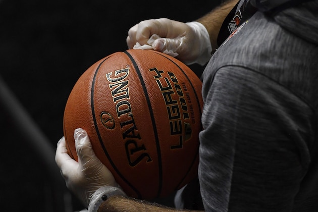 Basketballs, to be used in an upcoming NCAA college basketball game between San Francisco and Virginia, are disinfected with alcohol wipes, Friday, Nov. 27, 2020, in Uncasville, Conn. (AP Photo/Jessica Hill)
