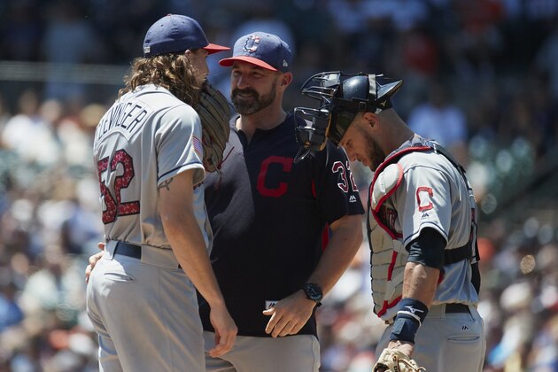 Cleveland Indians pitching coach Mickey Callaway, center talks to starting pitcher Mike Clevinger and catcher Yan Gomes during the first inning of a baseball game against the Detroit Tigers in Detroit, Sunday, July 2, 2017. (AP Photo/Rick Osentoski)