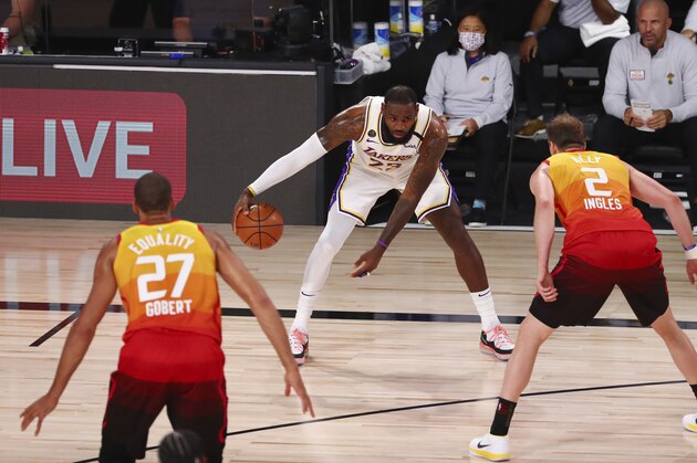 Los Angeles Lakers forward LeBron James (23) is defended by Utah Jazz guard Joe Ingles (2) and center Rudy Gobert (27) during the first half of an NBA basketball game Monday, Aug. 3, 2020, in Lake Buena Vista, Fla. (Kim Klement/Pool Photo via AP)