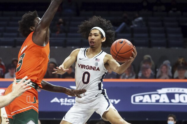Virginia guard Kihei Clark (0) passes the ball around Miami center Nysier Brooks (3) during an NCAA college basketball game, Monday, March 1, 2021, in Charlottesville, Va. (Andrew Shurtleff/The Daily Progress via AP, Pool)