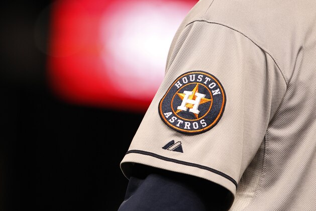 Houston Astros logo shines off sleeve of first base coach Dave Clark in the ninth inning of Astros' 6-3 victory over the Colorado Rockies in a baseball game in Denver on Wednesday, May 29, 2013. (AP Photo/David Zalubowski)