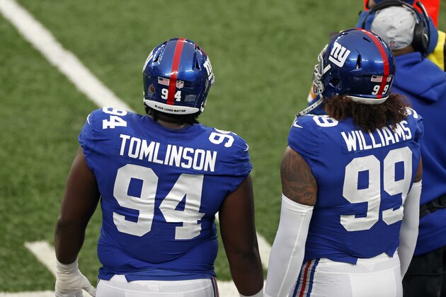 New York Giants nose tackle Dalvin Tomlinson (94) looks on with defensive end Leonard Williams (99) during an NFL football game against the Dallas Cowboys, Sunday, Jan. 3, 2021, in East Rutherford, N.J. Tomlinson is seen with the words 'Black Lives Matter' and the 'Walter Payton Man Of The Year' sticker on his helmet. (AP Photo/Adam Hunger)