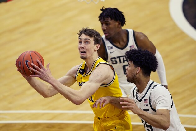 Michigan guard Franz Wagner (21) looks to shoot as Michigan State forward Malik Hall (25) defends during the first half of an NCAA college basketball game, Sunday, March 7, 2021, in East Lansing, Mich. (AP Photo/Carlos Osorio)