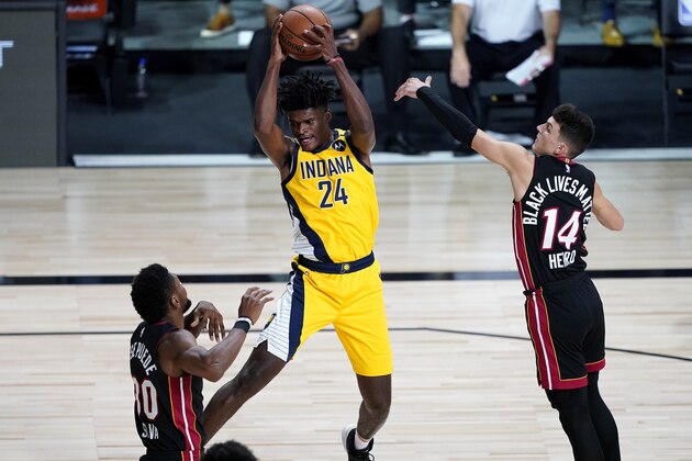 Indiana Pacers' Alize Johnson (24) pulls down a rebound as Miami Heat's Tyler Herro (14) and Chris Silva (30) defend during the first half of an NBA basketball game Monday, Aug. 3, 2020, in Lake Buena Vista, Fla. (AP Photo/Ashley Landis, Pool)