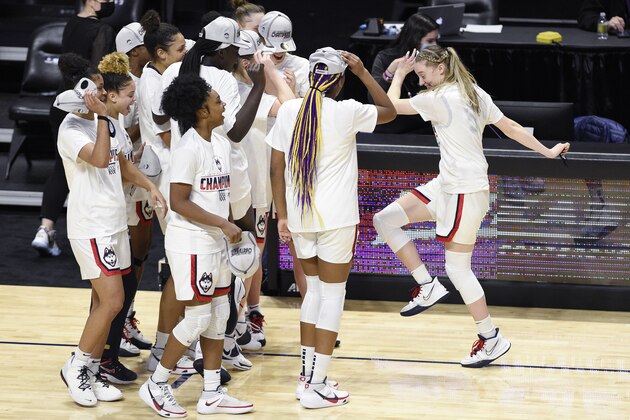 Connecticut's Paige Bueckers, right, dances over to teammates while celebrating an NCAA college basketball game win in the Big East tournament finals against Marquette at Mohegan Sun Arena, Monday, March 8, 2021, in Uncasville, Conn. (AP Photo/Jessica Hill)