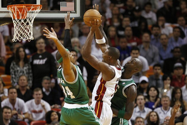Miami Heat's Chris Bosh (1) slides between Boston Celtics players Kevin Garnett (5) and Paul Pierce (34) during the second half of a NBA basketball game in MIami, Tuesday, Oct. 30, 2012. The Heat won 120-107. (AP Photo/J Pat Carter)