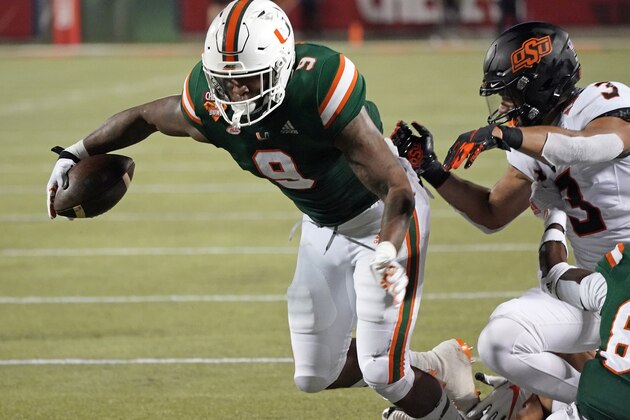 Miami tight end Brevin Jordan (9) makes a move to get by Oklahoma State safety Tre Sterling (3) during the second half of the Cheez-it Bowl NCAA college football game, Tuesday, Dec. 29, 2020, in Orlando, Fla. (AP Photo/John Raoux)