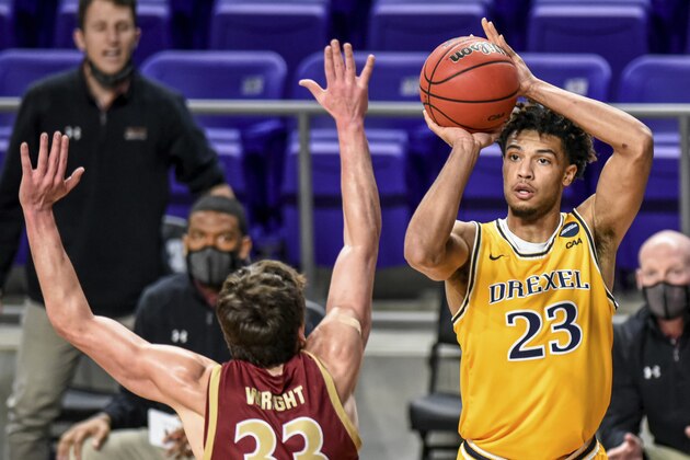Drexel forward T.J. Bickerstaff (23) shoots over Elon forward Simon Wright (33) during the first half of an NCAA college basketball game for the Colonial Athletic Association men's tournament championship in Harrisonburg, Va., Tuesday, March 9, 2021. (AP Photo/Daniel Lin)