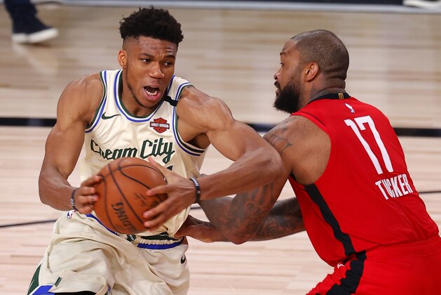 Milwaukee Bucks' Giannis Antetokounmpo drives on Houston Rockets' P.J. Tucker during an NBA basketball game Sunday, Aug. 2, 2020, in Lake Buena Vista, Fla. (Mike Ehrmann/Pool Photo via AP)