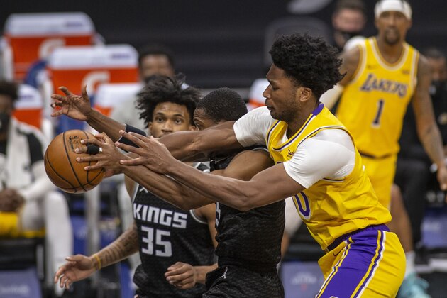 Los Angeles Lakers center Damian Jones (30) fights for the ball against Sacramento Kings guard De'Aaron Fox (5) as teammate Marvin Bagley III (35) assists on defense during the second quarter of an NBA basketball game in Sacramento, Calif., Wednesday, March 3, 2021. (AP Photo/Hector Amezcua)