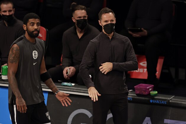 Brooklyn Nets guard Kyrie Irving (11) walks past head coach Steve Nash during an NBA basketball game against the Atlanta Hawks, Friday, Jan. 1, 2021, in New York. The Hawks won 114-96. (AP Photo/Adam Hunger)