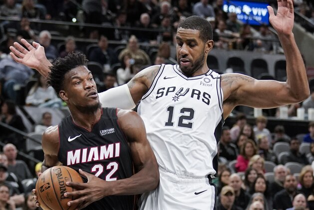 Miami Heat's Jimmy Butler (22) drives around San Antonio Spurs' LaMarcus Aldridge during the first half of an NBA basketball game, Sunday, Jan. 19, 2020, in San Antonio. (AP Photo/Darren Abate)
