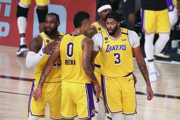 Los Angeles Lakers forward LeBron James (23) and forward Kyle Kuzma (0) and guard Kentavious Caldwell-Pope, second from right, and forward Anthony Davis (3) huddle during the first half against the Portland Trail Blazers during Game 2 of an NBA basketball first-round playoff series, Thursday, Aug. 20, 2020, in Lake Buena Vista, Fla. (Kim Klement/Pool Photo via AP)