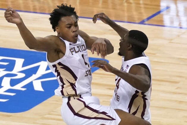 Florida State guard Scottie Barnes, left, and teammate Florida State guard Sardaar Calhoun (24) celebrate their 69-66 win over North Carolina of an NCAA college basketball game in the semifinal round of the Atlantic Coast Conference tournament in Greensboro, N.C., Friday, March 12, 2021. (AP Photo/Gerry Broome)