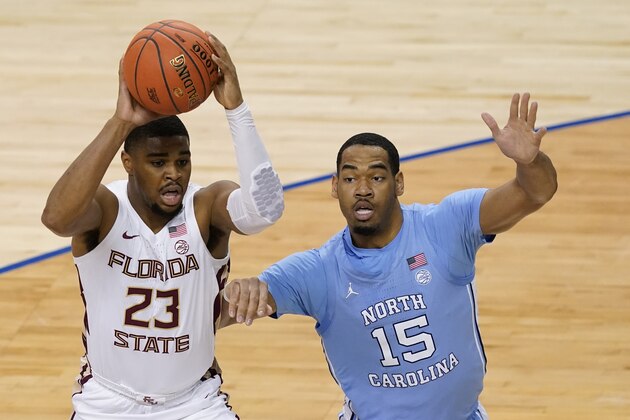 Florida State guard M.J. Walker (23) looks for help as North Carolina forward Garrison Brooks (15) pressures during the first half of an NCAA college basketball game in the semifinal round of the Atlantic Coast Conference tournament in Greensboro, N.C., Friday, March 12, 2021. (AP Photo/Gerry Broome)