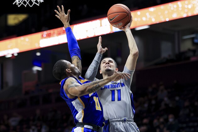 Xavier guard Dwon Odom defends as Creighton guard Marcus Zegarowski (11) drives to the basket during the second half of an NCAA college basketball game Saturday, Feb. 27, 2021, in Cincinnati. Xavier won 77-69. (AP Photo/Aaron Doster)