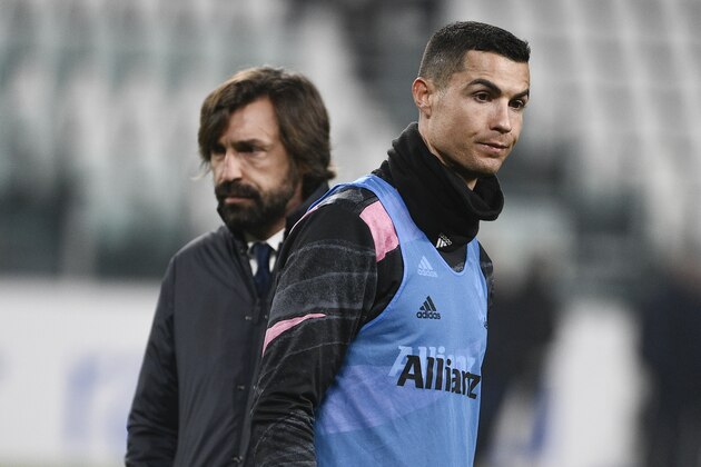 Juventus coach Andrea Pirlo, left, and Cristiano Ronaldo walk on the pitch prior to the Serie A soccer match between Juventus and Crotone, at the Allianz Stadium in Turin, Italy, Monday, Feb. 22, 2021. (Marco Alpozzi/LaPresse via AP)