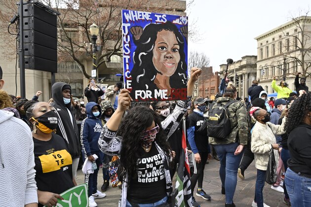 A protester holds up a painting of Breonna Taylor during a rally on the one year anniversary of her death at Jefferson Square Park in Louisville, Ky., Saturday, March 13, 2021. (AP Photo/Timothy D. Easley)