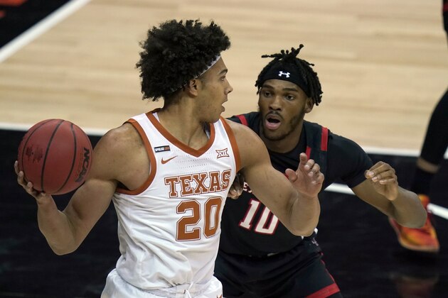 Texas forward Jericho Sims (20) looks to pass while covered by Texas Tech Red forward Tyreek Smith (10) during the first half of an NCAA college basketball game in the quarterfinal round of the Big 12 men's tournament in Kansas City, Mo., Thursday, March 11, 2021. (AP Photo/Orlin Wagner)