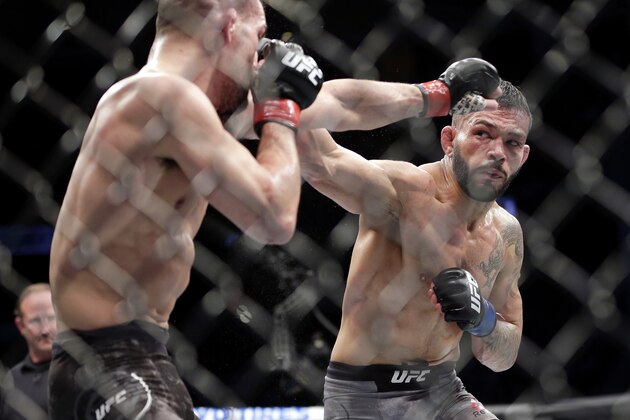 Mirsad Bektic, left, defends the punch by Dan Ige during the third round of a featherweight mixed martial arts bout at UFC 247 on Saturday, Feb. 8, 2020, in Houston. (AP Photo/Michael Wyke)