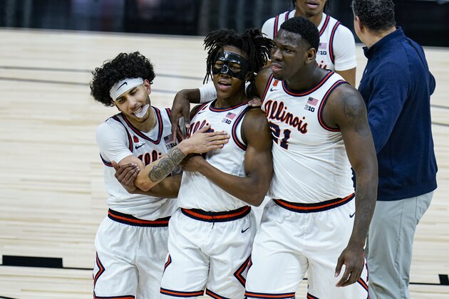 Illinois' Andre Curbelo, left, Ayo Dosunmu, center and Kofi Cockburn (21) hug as they leave the court following an 82-71 win over Iowa in an NCAA college basketball game at the Big Ten Conference tournament in Indianapolis, Saturday, March 13, 2021. (AP Photo/Michael Conroy)