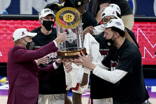 Alabama head coach Nate Oats, left, and players lift the trophy after the championship game of the NCAA college basketball Southeastern Conference Tournament between Alabama and LSU Sunday, March 14, 2021, in Nashville, Tenn. Alabama won 80-79. (AP Photo/Mark Humphrey)