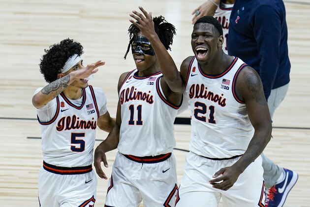 Illinois' Andre Curbelo, left, Ayo Dosunmu, center and Kofi Cockburn (21) hug as they leave the court following a 82-71 win over Iowa in an NCAA college basketball game at the Big Ten Conference tournament in Indianapolis, Saturday, March 13, 2021. (AP Photo/Michael Conroy)
