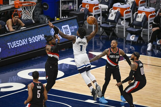 Minnesota Timberwolves guard Anthony Edwards (1) goes up to dunk over Portland Trail Blazers forward Robert Covington as Trail Blazers guard Rodney Hood (5), guard Damian LillardÂ (0) and  forward Carmelo Anthony (00) look on during the second half of an NBA basketball game Sunday, March 14, 2021, in Minneapolis. (AP Photo/Craig Lassig)