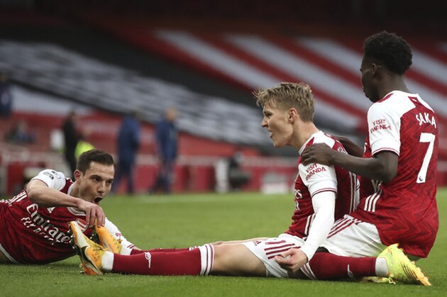 Arsenal's Martin Odegaard, centre, celebrates after scoring his side's opening goal during the English Premier League soccer match between Arsenal and Tottenham Hotspur at the Emirates stadium in London, England, Sunday, March 14, 2021. (Nick Potts/Pool via AP)