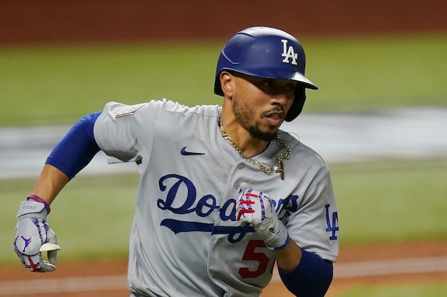 Los Angeles Dodgers' Mookie Betts runs to first after a RBI single against the Tampa Bay Rays during the fourth inning in Game 3 of the baseball World Series Friday, Oct. 23, 2020, in Arlington, Texas. (AP Photo/Eric Gay)