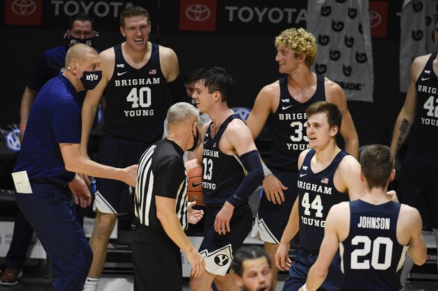 BYU head coach Mark Pope, left, celebrates with his players after they defeated San Diego State in an NCAA college basketball game Friday, Dec. 18, 2020, in San Diego. (AP Photo/Denis Poroy)