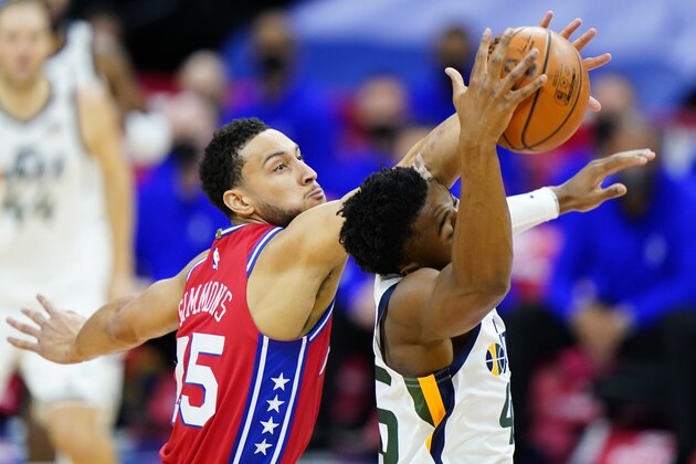 Philadelphia 76ers' Ben Simmons, left, and Utah Jazz's Donovan Mitchell reach for a loose ball during the first half of an NBA basketball game, Wednesday, March 3, 2021, in Philadelphia. (AP Photo/Matt Slocum)